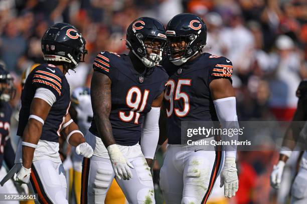 Yannick Ngakoue of the Chicago Bears is congratulated by Kyler Gordon and DeMarcus Walker of the Chicago Bears after making a tackle against the...