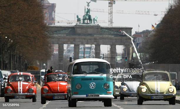 Vintage bus and beetle cars of German car maker Volkswagen drive past Berlin's landmark the Brandenburg Gate on April 23, 2013 in Berlin to promote a...
