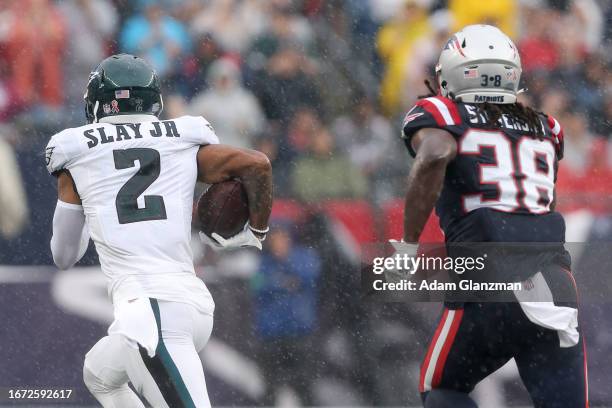 Darius Slay of the Philadelphia Eagles returns an interception for a touchdown while Rhamondre Stevenson of the New England Patriots chases after him...