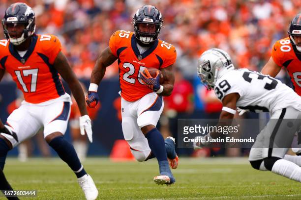 Samaje Perine of the Denver Broncos runs past Nate Hobbs of the Las Vegas Raiders during the first quarter at Empower Field At Mile High on September...