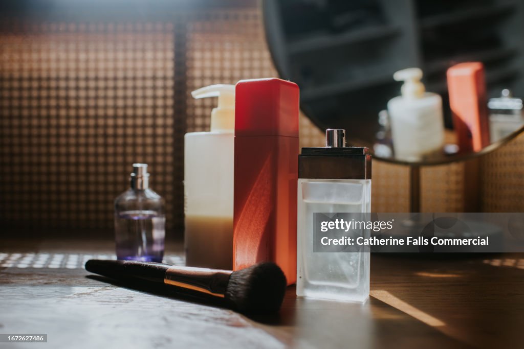 Various beauty products on a dressing table in front of a vanity mirror