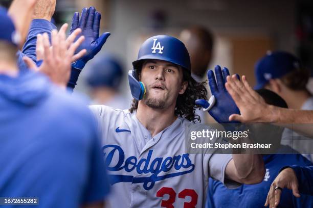 James Outman of the Los Angeles Dodgers is congratulated by teammates in the dugout after hitting a solo home run during the eighth inning against...