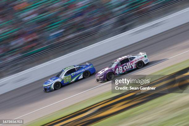 Alex Bowman, driver of the Ally Chevrolet, and Daniel Suarez, driver of the Freeway.com Chevrolet, race during the NASCAR Cup Series Hollywood Casino...