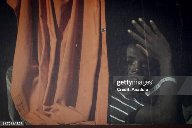 Migrant boy is seen in a bus as the massive transfer of migrants is taking place from the Sicilian island of Lampedusa to the Italian mainland to...