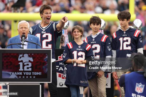 New England Patriots owner Robert Kraft speaks while former New England Patriots quarterback Tom Brady points towards the crowd while Brady's...