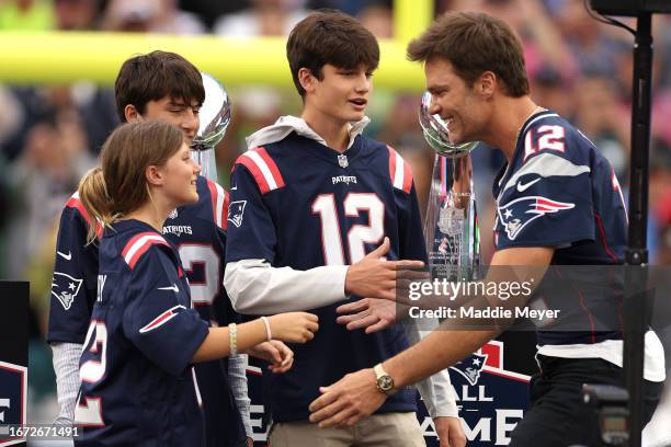 Former New England Patriots quarterback Tom Brady hugs his daughter, Vivian, while his sons, Benjamin and Jack, look on during a ceremony honoring...