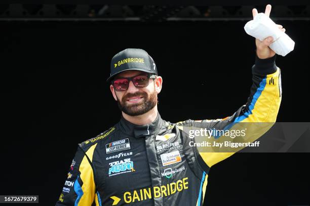 Corey LaJoie, driver of the Gainbridge Chevrolet, waves to fans as he walks onstage during driver intros prior to the NASCAR Cup Series Hollywood...