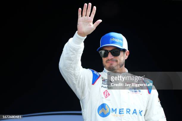 Yeley, driver of the Jungle Law Ford, waves to fans as he walks onstage during driver intros prior to the NASCAR Cup Series Hollywood Casino 400 at...