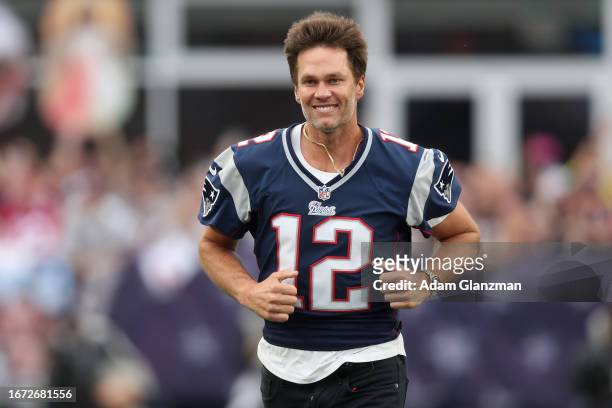 Former New England Patriots quarterback Tom Brady jogs onto the field during a ceremony honoring Brady at halftime of New England's game against the...