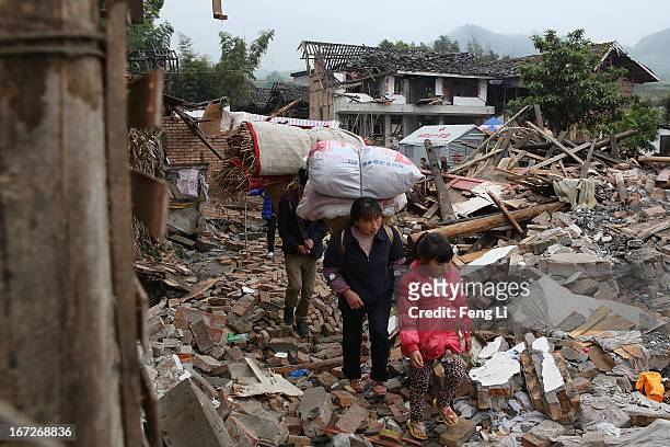 Earthquake survivors walk past the ruins of their house on April 23, 2013 in Longmen township of Lushan county, China. A magnitude 7 earthquake hit...