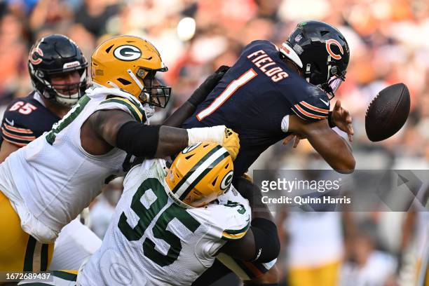 Justin Fields of the Chicago Bears fumbles the ball against the Devonte Wyatt of the Green Bay Packers during the second half at Soldier Field on...