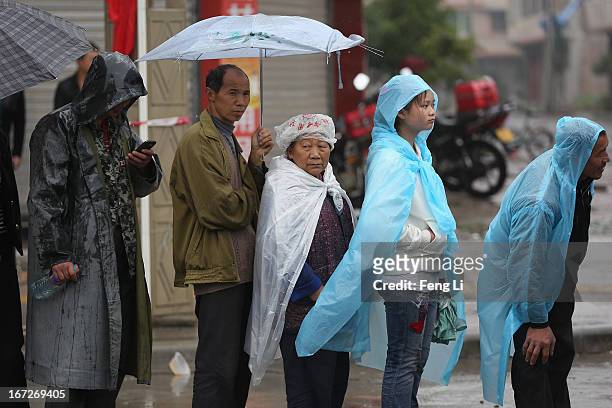 Earthquake survivors queue for free food in the rain on April 23, 2013 in Lushan of Ya An, China. A magnitude 7 earthquake hit China's Sichuan...