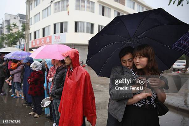 Earthquake survivors queue for free food in the rain on April 23, 2013 in Lushan of Ya An, China. A magnitude 7 earthquake hit China's Sichuan...