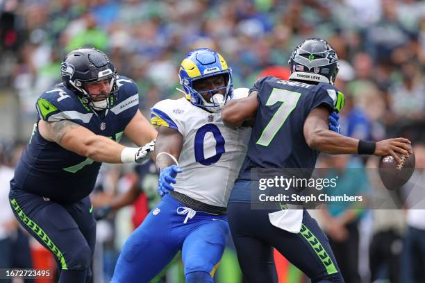 Geno Smith of the Seattle Seahawks is hit by Byron Young of the Los Angeles Rams during the second half at Lumen Field on September 10, 2023 in...