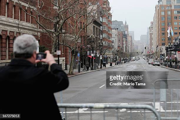 Man take photos at a barricade blocking a still closed section of Boylston Street near the site of the Boston Marathon bombings on April 23, 2013 in...