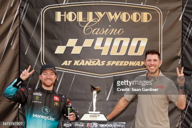 Tyler Reddick MoneyLion Toyota, driver of the 23XI Racing, and 23XI Racing co-owner, Denny Hamlin pose for photos in victory lane after winning the...