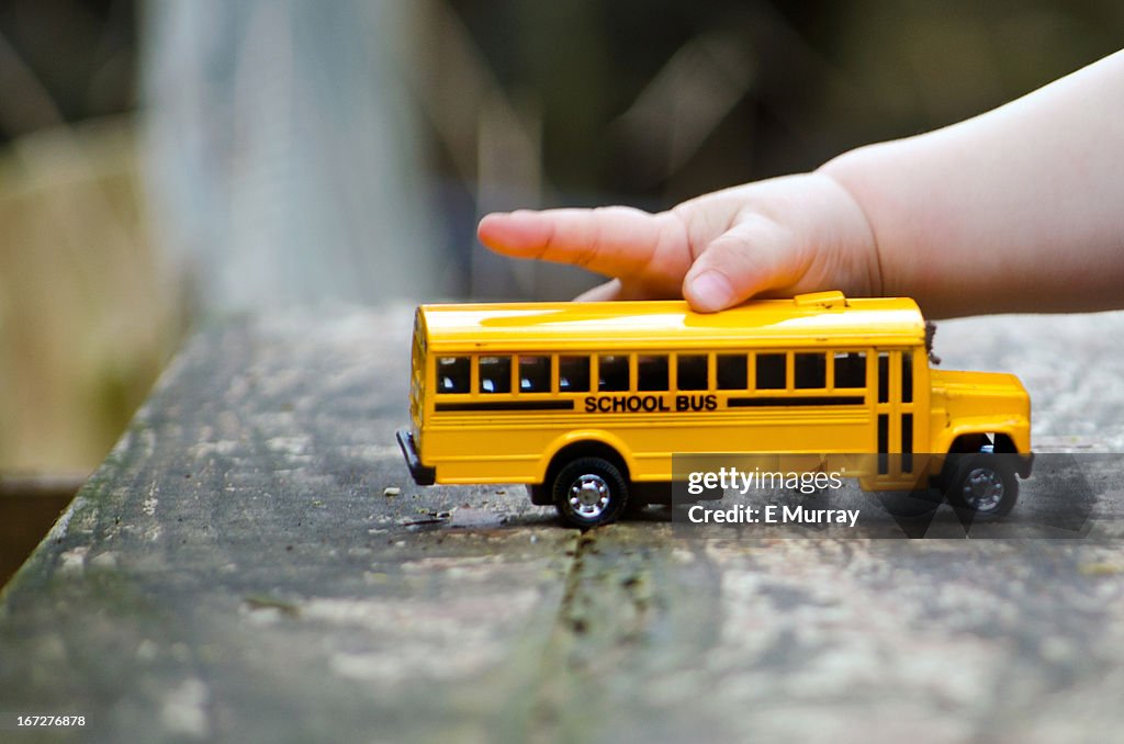 Child holding toy school bus