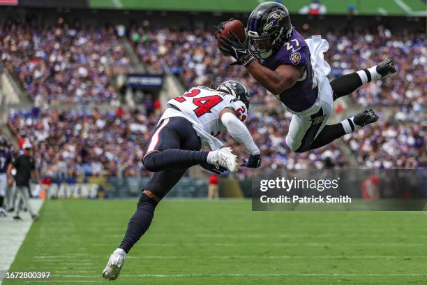 Dobbins of the Baltimore Ravens dives into the end zone past Derek Stingley Jr. #24 of the Houston Texans for a touchdown in the first quarter at M&T...