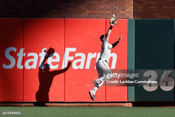 Mike Yastrzemski of the San Francisco Giants catches an RBI sacrifice fly ball hit by Sean Bouchard of the Colorado Rockies in the top of the second...