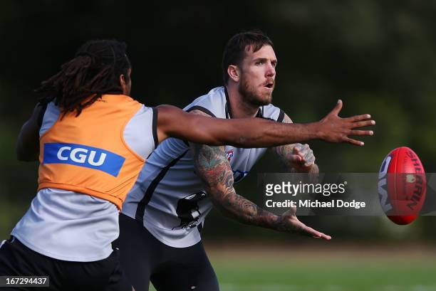Dane Swan handpasses the ball past Harry O'Brien during a Collingwood Magpies AFL training session at Olympic Park on April 24, 2013 in Melbourne,...