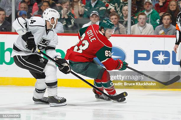 Charlie Coyle of the Minnesota Wild and Davis Drewiske of the Los Angeles Kings skate to the puck during the game on April 23, 2013 at the Xcel...