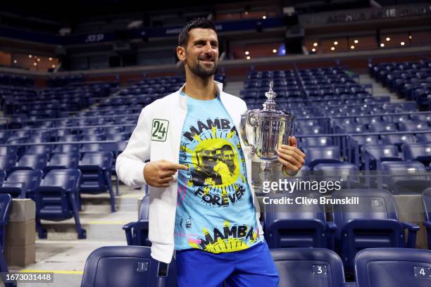 Novak Djokovic of Serbia poses for the media with his winners trophy wearing a shirt as a tribute to the late Kobe Bryant after defeating Daniil...