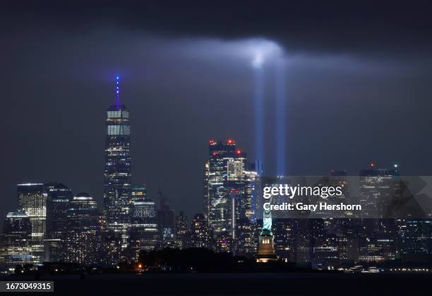 The annual Tribute in Light is illuminated above the skyline of lower Manhattan, One World Trade Center, and the Statue of Liberty as it is set up to...