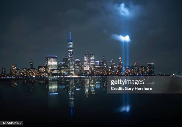 The annual Tribute in Light is illuminated above the skyline of lower Manhattan and One World Trade Center and the Statue of Liberty as it is set up...