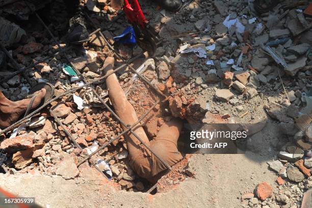 The dead body of a Bangladeshi youth is seen in the rubble after the Rana Plaza garment building collapsed in Savar, on the outskirts of Dhaka, on...
