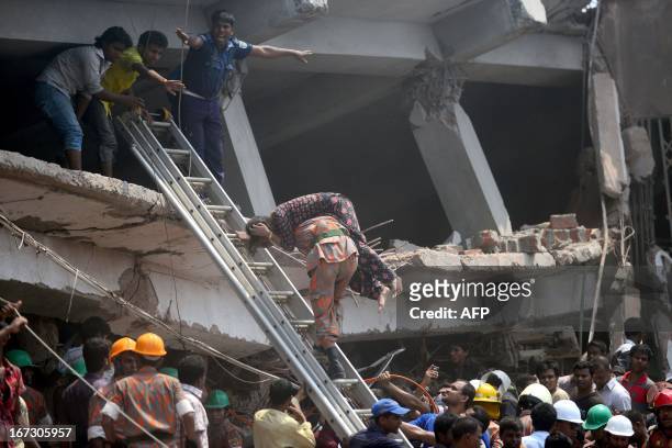 Bangladeshi firefighter carries an injured garment worker after the Rana Plaza garment building collapsed in Savar, on the outskirts of Dhaka, on...