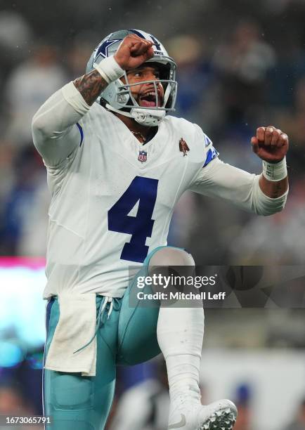 Dak Prescott of the Dallas Cowboys reacts after a touchdown run by KaVontae Turpin during the fourth quarter against the New York Giants at MetLife...