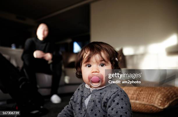 bebé con chupete y su madre sentada en el sofá - sofá 個照片及圖片檔
