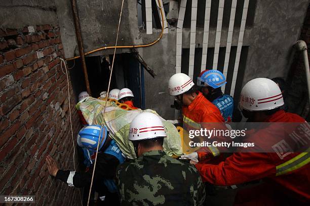 Rescuers carry a victim's body out of a damaged building on April 23, 2013 in Lushan County, China. A powerful earthquake struck the steep hills of...