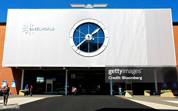 Visitors enter and exit the Baselworld watch fair in Basel, Switzerland, on Wednesday, April 24, 2013. The annual fair attracts 2,000 companies from...
