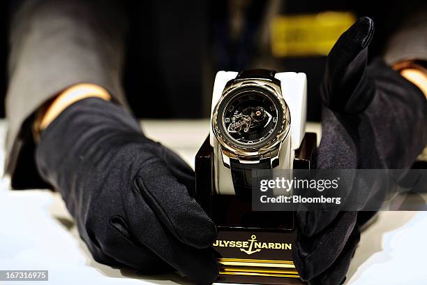 Technician arranges a wristwatch in a display case at the Ulysse Nardin SA booth during the Baselworld watch fair in Basel, Switzerland, on...