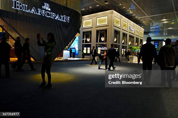 Visitors pass the Blancpain booth, left and Chopard booth at the Baselworld watch fair in Basel, Switzerland, on Wednesday, April 24, 2013. The...