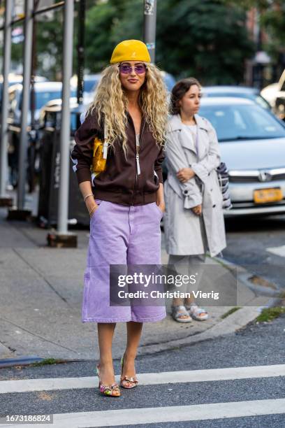 Emili Sindlev wears yellow hat, brown zipper, pink shorts outside Area on September 10, 2023 in New York City.