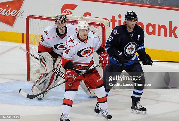 Bobby Sanguinetti of the Carolina Hurricanes and Andrew Ladd of the Winnipeg Jets keep an eye on the play as they screen goaltender Justin Peters...