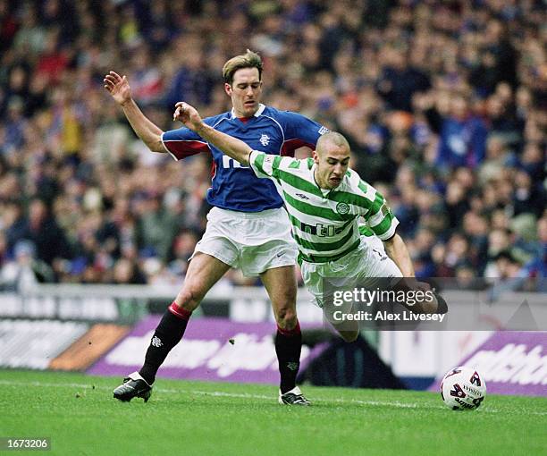 Henrik Larsson of Celtic is sent flying by the challenge of Fernando Ricksen of Rangers during the Scottish Premier Division match held on March 10,...