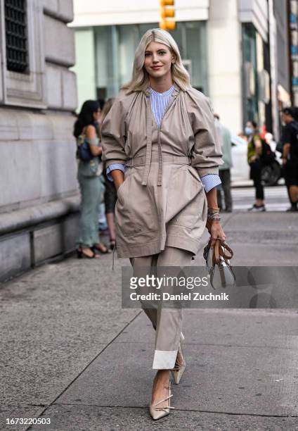 Devon Windsor is seen wearing a tan coat, blue and white strip button down and tan pants with a white and brown leather bag outside the 3.1 Phillip...