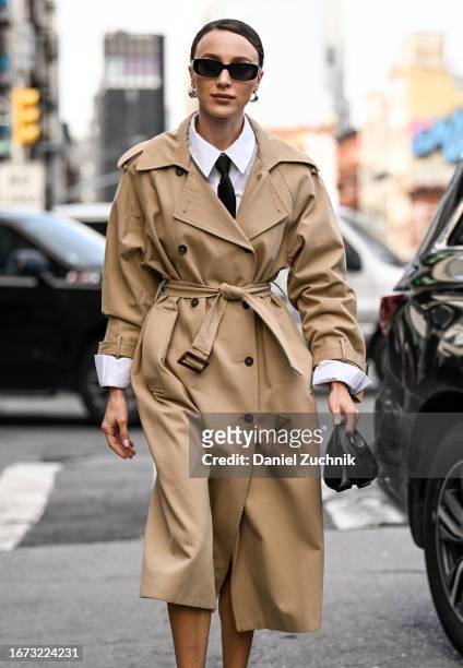 Mary Leest is seen wearing a tan trench coat, white shirt, black tie, black sunglasses, black bag outside the 3.1 Phillip Lim show during NYFW S/S...