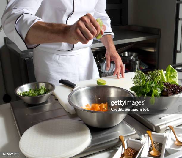 cook squeezing lemon on vegetable in cooking pot - squeezing lemon stock pictures, royalty-free photos & images