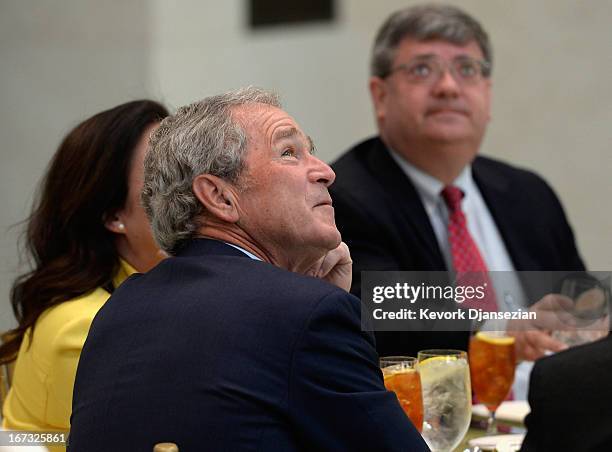 Former President George W. Bush looks at the 360-degree LED high definition video wall inside the Freedom Hall as he participates in a signing...
