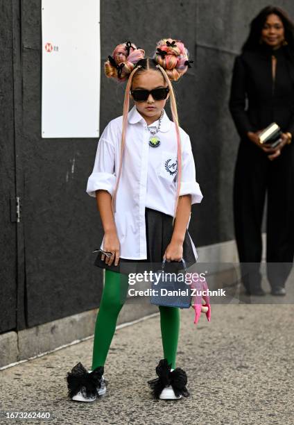 Guest is seen wearing a white button down shirt, charcoal skirt, green tights, black tule and white shoes and a blue bag with black sunglasses...