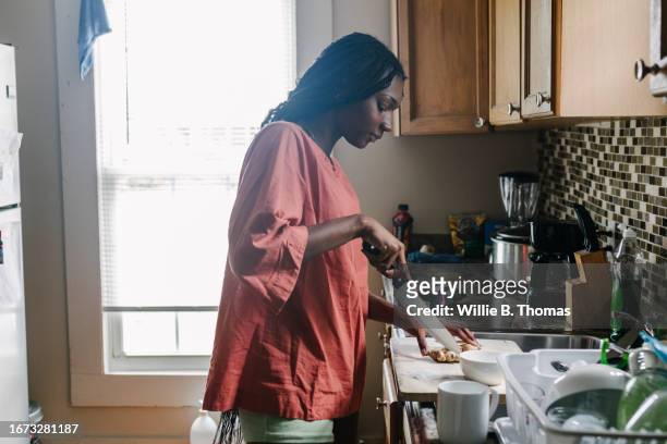 woman slicing vegetables on kitchen couter at home - ��couter stockfoto's en -beelden