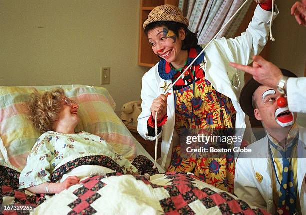 Clowns Dollee Mallare, center, and Robb Preskins entertain Children's Hospital patient Lara Graveline as part of the Big Apple Circus Clown Care Unit.