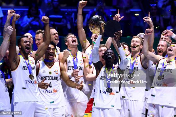 Dennis Schroder of Germany lifts the Naismith Trophy as he celebrates with teammates after the FIBA Basketball World Cup Final victory over Serbia at...