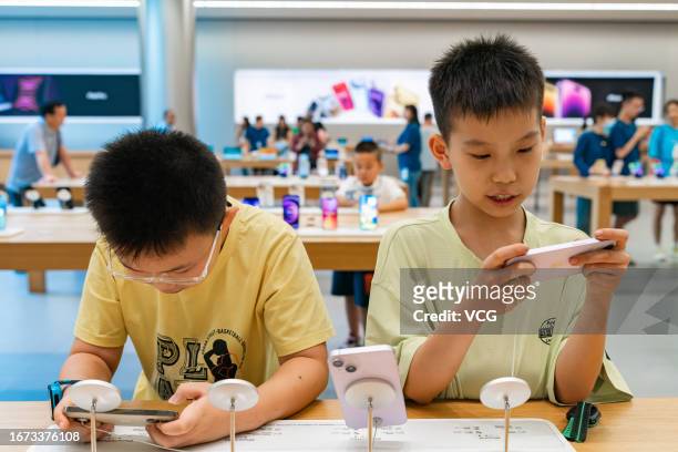Children try out iPhones at an Apple Store on September 10, 2023 in Chongqing, China.