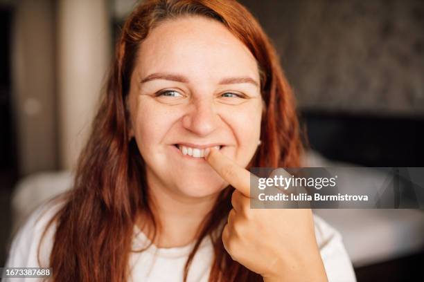 confident redhead lady picking teeth with meticulous adherence to personal hygiene - toothpick stock pictures, royalty-free photos & images