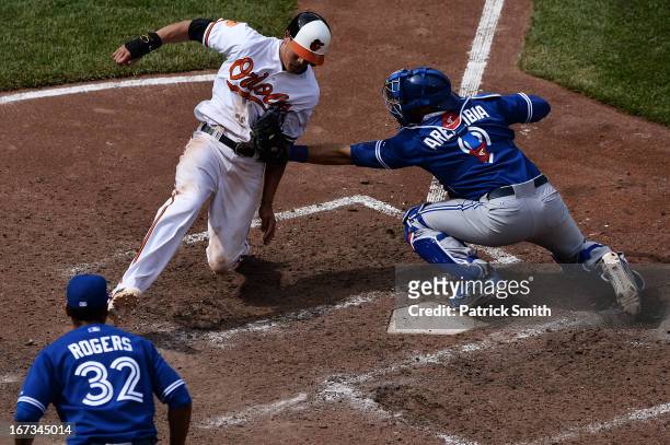 Catcher J.P. Arencibia of the Toronto Blue Jays tags out base runner Manny Machado of the Baltimore Orioles in the tenth inning at Oriole Park at...